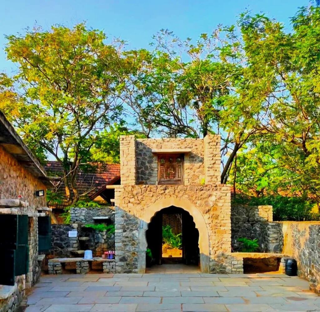 Historic stone gateway and heritage streetscape at DakshinaChitra Museum Chennai