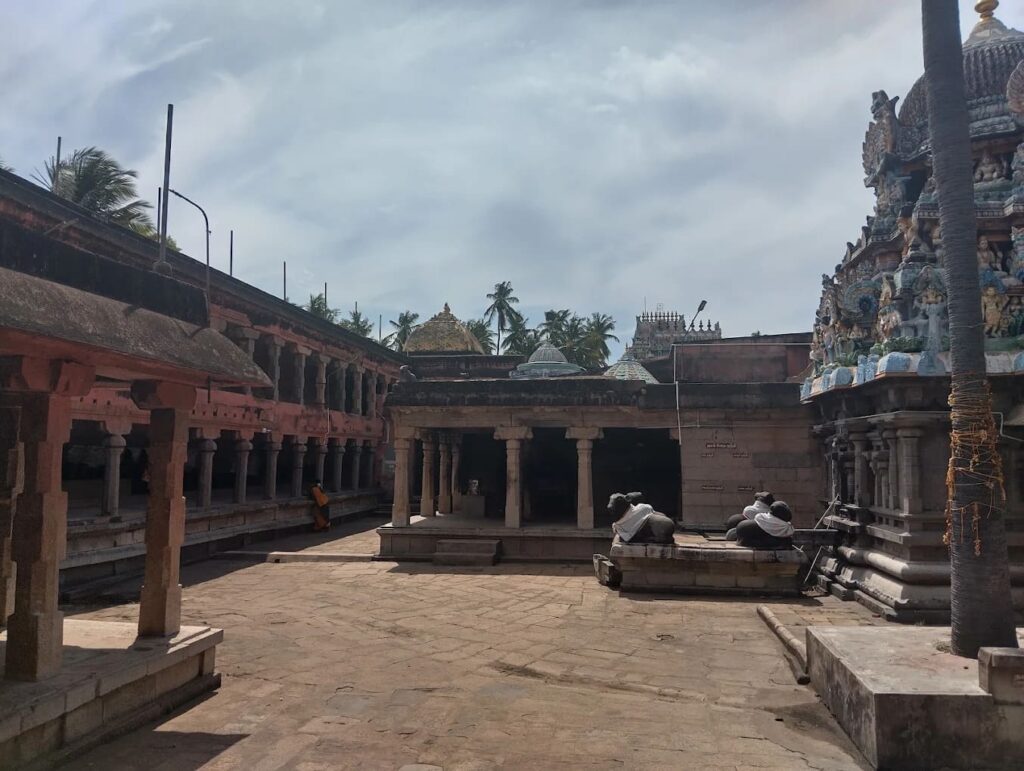 Inner courtyard of a large South Indian temple with stone mandapams and a central shrine