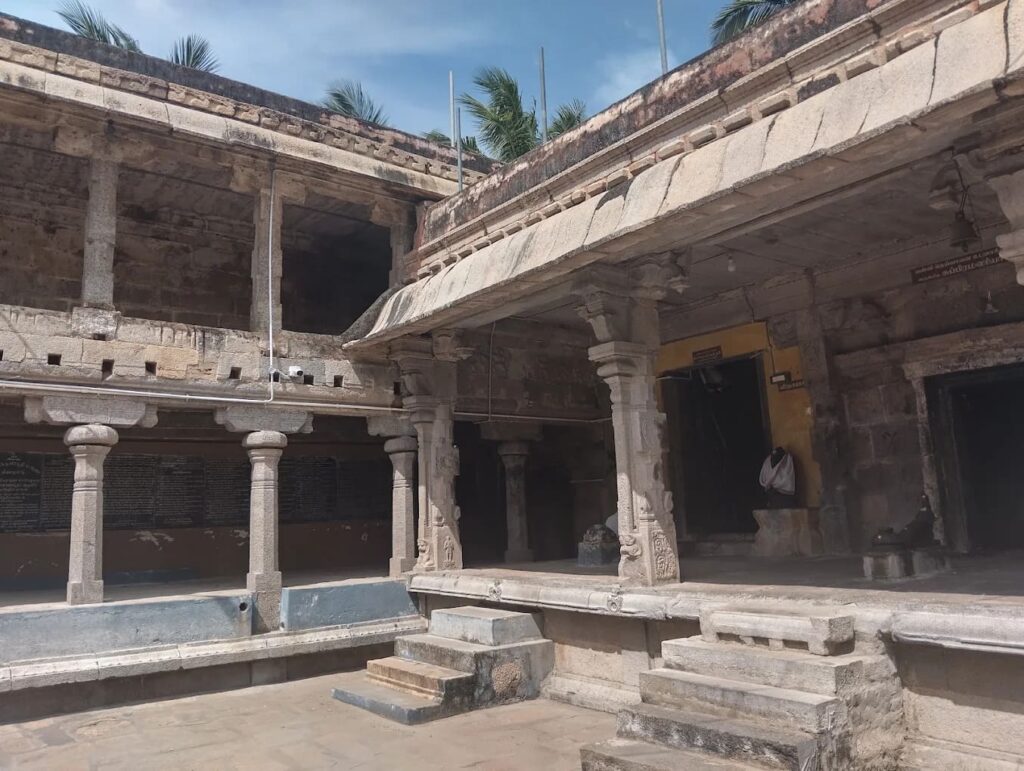 Long hallway with rows of carved granite pillars in an ancient Indian temple