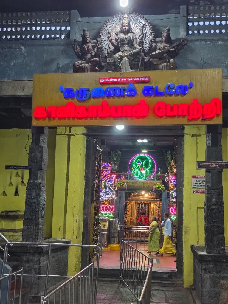 Entrance of Kalikambal Temple featuring a Tamil signboard and decorated doorway